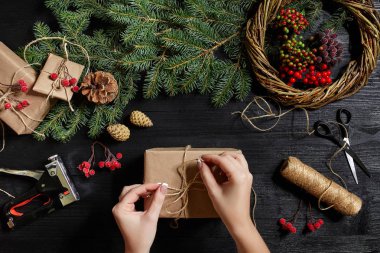 En iyi eller görünümünü yeni yıl hediyesi sarın. Yemeği hediyeler ve verilirse, şube ve ahşap masa üstünde alet çeki düzen vermek.