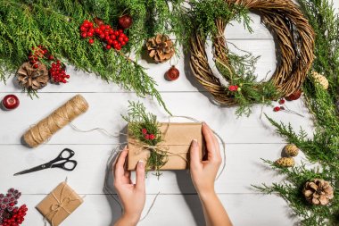 En iyi eller görünümünü yeni yıl hediyesi sarın. Yemeği hediyeler ve verilirse, şube ve ahşap masa üstünde alet çeki düzen vermek.