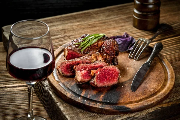 레드 와인, 허브와 향신료 나무 테이블에 ribeye 쇠고기 스테이크 구이 — 스톡 사진