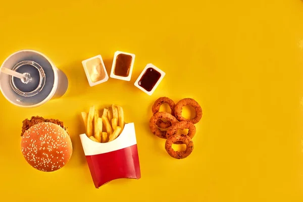快餐和不健康的饮食概念-在黄色背景下的快餐小吃和冷饮的关闭 — 图库照片