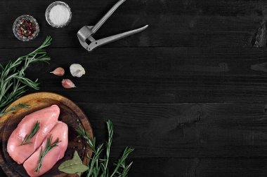 Otlar ve baharatlar ile ahşap kesme tahtası üzerinde çiğ tavuk göğsü fileto. kopya alanı ile Üstten Görünüm