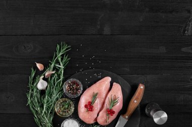 Malzemeler siyah arduvaz masada yemek ile çiğ tavuk fileto. Gıda arka plan. Üstten Görünüm, kopya alanı.
