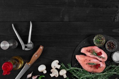 Tavuk göğsü rustik ahşap arka plan üzerinde farklı sebze ve otlar ile kesme tahtası.