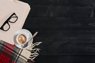 Gazete, kahve fincanı, eşarp, gözlük ile çalışma alanı. Şık Ofis Masası. Sonbahar ya da kış kavramı. Düz yatıyordu, en iyi görünümü