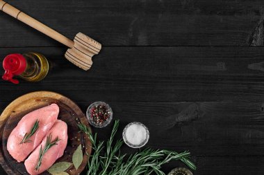 Otlar ve baharatlar ile ahşap kesme tahtası üzerinde çiğ tavuk göğsü fileto. kopya alanı ile Üstten Görünüm