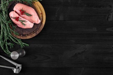 Otlar ve baharatlar ile ahşap kesme tahtası üzerinde çiğ tavuk göğsü fileto. kopya alanı ile Üstten Görünüm