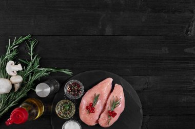 Tavuk göğsü rustik ahşap arka plan üzerinde farklı sebze ve otlar ile kesme tahtası.