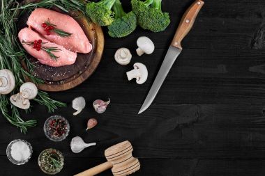 Çiğ tavuk göğsü fileto otlar, baharatlar ve sebzeler ile ahşap kesme tahtası üzerinde. Kopya alanı ile Üstten Görünüm