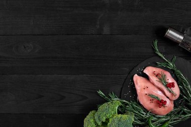 Pişirme tavuk göğsü. Masanın üzerine baharat - biberiye, kırmızı ve karabiber vardır. Kavram - sağlıklı gıda.