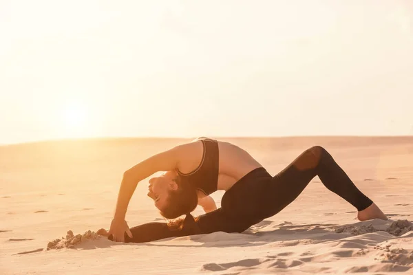 Fitness Yoga Frau dehnt sich auf Sand. fitte Sportlerin in Yoga-Pose. — Stockfoto