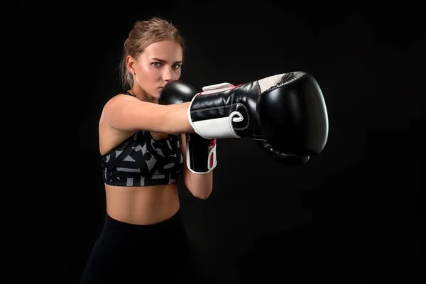 Hermosa atleta femenina en guantes de boxeo, en el estudio sobre un fondo negro. Concéntrate en el guante — Foto de Stock