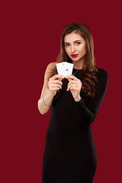 Hermosa mujer caucásica en vestido negro con cartas de póquer de juego en el casino — Foto de Stock