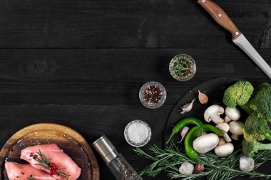 Otlar ve baharatlar ile ahşap kesme tahtası üzerinde çiğ tavuk göğsü fileto. kopya alanı ile Üstten Görünüm