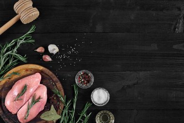 Otlar ve baharatlar ile ahşap kesme tahtası üzerinde çiğ tavuk göğsü fileto. kopya alanı ile Üstten Görünüm