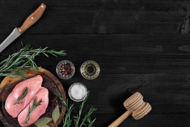 Otlar ve baharatlar ile ahşap kesme tahtası üzerinde çiğ tavuk göğsü fileto. kopya alanı ile Üstten Görünüm