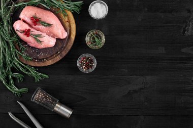 Otlar ve baharatlar ile ahşap kesme tahtası üzerinde çiğ tavuk göğsü fileto. kopya alanı ile Üstten Görünüm