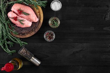 Otlar ve baharatlar ile ahşap kesme tahtası üzerinde çiğ tavuk göğsü fileto. kopya alanı ile Üstten Görünüm