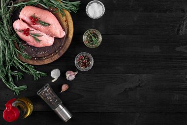 Otlar ve baharatlar ile ahşap kesme tahtası üzerinde çiğ tavuk göğsü fileto. kopya alanı ile Üstten Görünüm