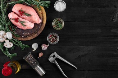 Çiğ tavuk göğsü fileto otlar, baharatlar ve mantar ile ahşap kesme tahtası üzerinde. Kopya alanı ile Üstten Görünüm