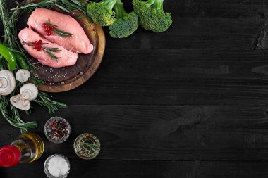 Çiğ tavuk göğsü fileto otlar, baharatlar ve sebzeler ile ahşap kesme tahtası üzerinde. Kopya alanı ile Üstten Görünüm