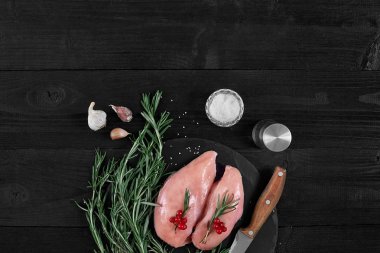 Pişirme tavuk göğsü. Masanın üzerine baharat - biberiye, kırmızı ve karabiber vardır. Kavram - sağlıklı gıda.