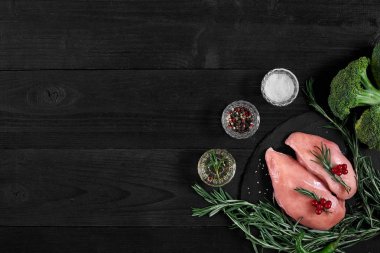 Pişirme tavuk göğsü. Masanın üzerine baharat - biberiye, kırmızı ve karabiber vardır. Kavram - sağlıklı gıda.