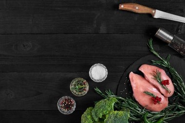 Pişirme tavuk göğsü. Masanın üzerine baharat - biberiye, kırmızı ve karabiber vardır. Kavram - sağlıklı gıda.