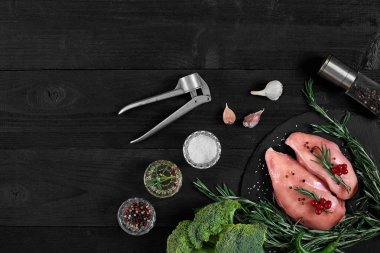 Tavuk göğsü rustik ahşap arka plan üzerinde farklı sebze ve otlar ile kesme tahtası.