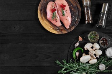 Otlar ve baharatlar ile ahşap kesme tahtası üzerinde çiğ tavuk göğsü fileto. kopya alanı ile Üstten Görünüm