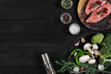 Otlar ve baharatlar ile ahşap kesme tahtası üzerinde çiğ tavuk göğsü fileto. kopya alanı ile Üstten Görünüm