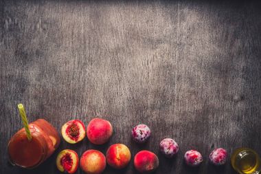 Şeftali ve Erik meyve güler yüzlü cam şişe ve payet ahşap masa üzerinde. Sağlıklı bir yaşam tarzı. Tonda