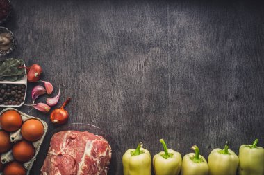 Çiğ domuz eti koyu ahşap yüzey ve yemek pişirmek için malzemeler. Gıda arka plan kopya alanı ile.