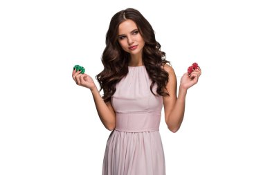 Renkli poker fişleri tutan bir şık yavaşça pembe elbiseli seksi kadın. Kazanan kadın