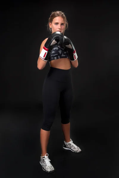 Hermosa atleta femenina en guantes de boxeo, en el estudio sobre un fondo negro . —  Fotos de Stock