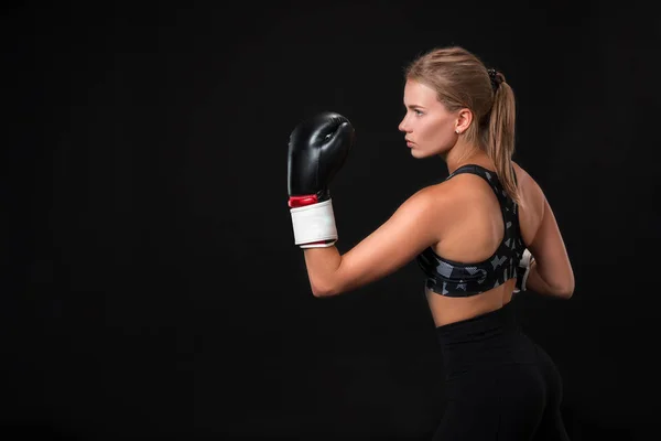 Hermosa atleta femenina en guantes de boxeo, en el estudio sobre un fondo negro . — Foto de Stock