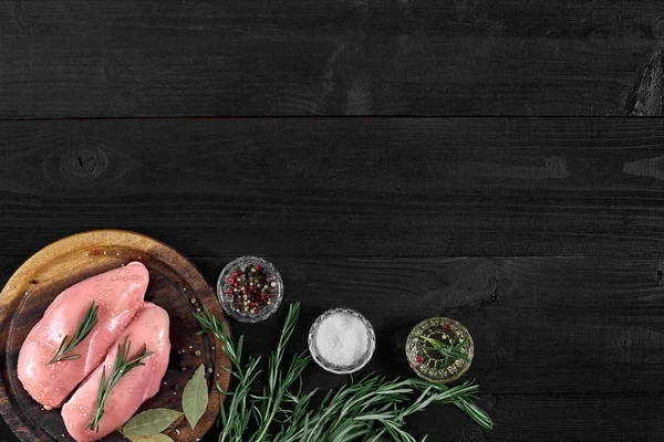 Otlar ve baharatlar ile ahşap kesme tahtası üzerinde çiğ tavuk göğsü fileto. kopya alanı ile Üstten Görünüm