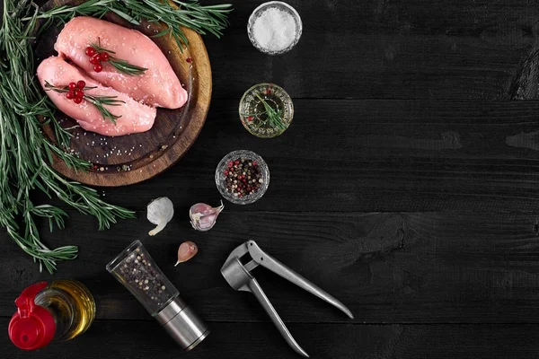 Otlar ve baharatlar ile ahşap kesme tahtası üzerinde çiğ tavuk göğsü fileto. kopya alanı ile Üstten Görünüm