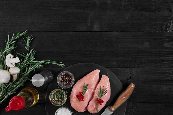 Tavuk göğsü rustik ahşap arka plan üzerinde farklı sebze ve otlar ile kesme tahtası.