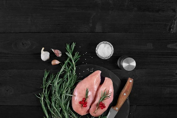 Pişirme tavuk göğsü. Masanın üzerine baharat - biberiye, kırmızı ve karabiber vardır. Kavram - sağlıklı gıda.