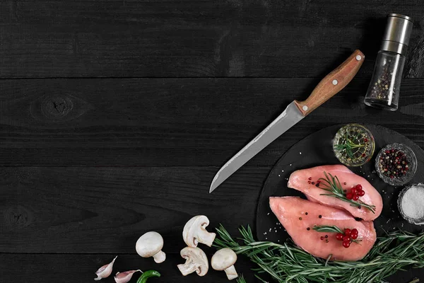 Tavuk göğsü rustik ahşap arka plan üzerinde farklı sebze ve otlar ile kesme tahtası.