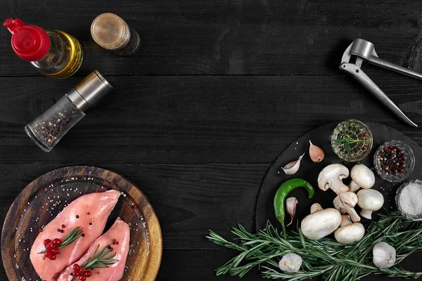 Otlar ve baharatlar ile ahşap kesme tahtası üzerinde çiğ tavuk göğsü fileto. kopya alanı ile Üstten Görünüm