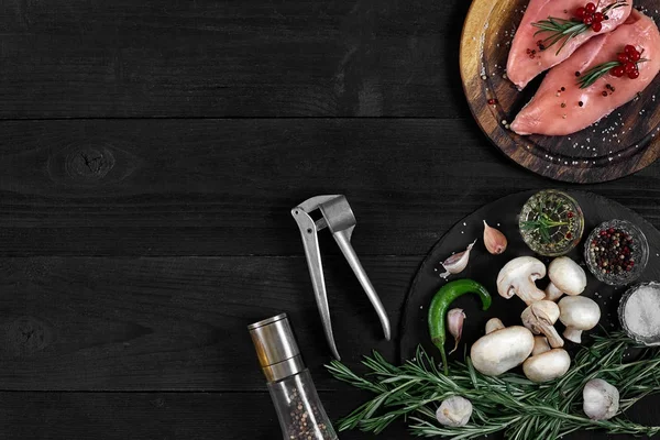 Otlar ve baharatlar ile ahşap kesme tahtası üzerinde çiğ tavuk göğsü fileto. kopya alanı ile Üstten Görünüm