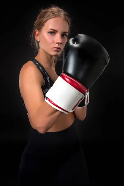 Linda atleta feminina em luvas de boxe, no estúdio em um fundo preto. Foco na luva — Fotografia de Stock