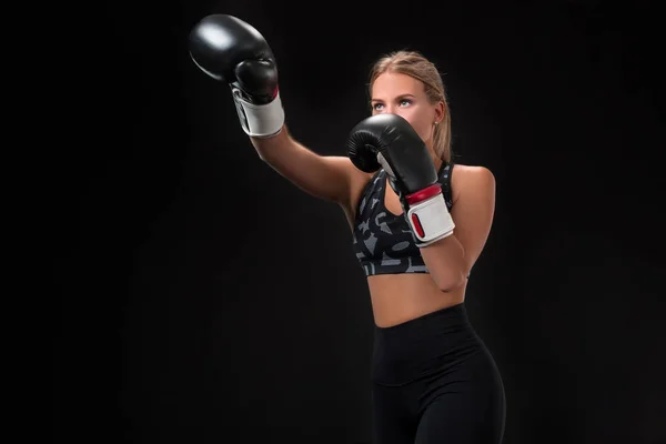 Linda atleta feminina em luvas de boxe, no estúdio em um fundo preto . — Fotografia de Stock