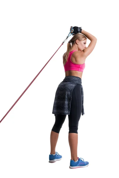 Silná žena pomocí odporu kapela v jejím cvičení v prostných. Mladá žena provádí fitness cvičení na bílém pozadí. — Stock fotografie
