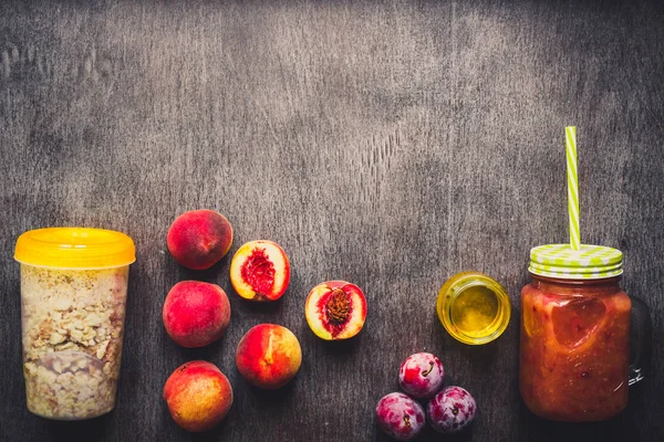 Batido de frutas de melocotón útil en botella de vidrio y pajitas y harina de avena con frutas, desayunos vegetarianos — Foto de Stock