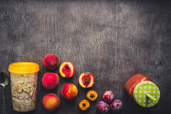 Batido de frutas de melocotón útil en botella de vidrio y pajitas y harina de avena con frutas, desayunos vegetarianos — Foto de Stock