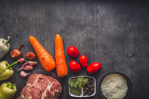 Çiğ domuz eti koyu ahşap yüzey ve yemek pişirmek için malzemeler. Gıda arka plan kopya alanı ile.