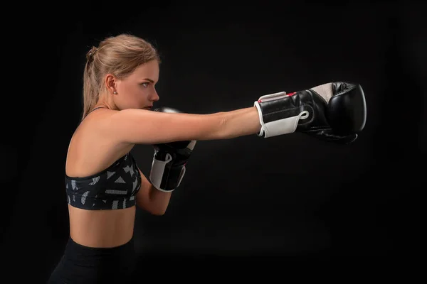 Hermosa atleta femenina en guantes de boxeo, en el estudio sobre un fondo negro . — Foto de Stock