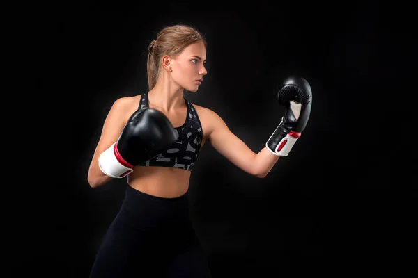 Hermosa atleta femenina en guantes de boxeo, en el estudio sobre un fondo negro . — Foto de Stock